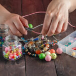 Woman with hand made jewellery on wooden table
